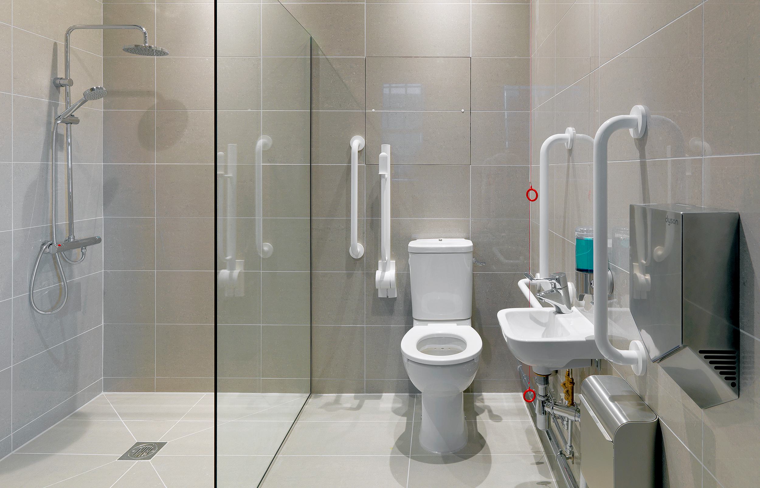 It has access to a disabled toilet, a magnetic glass board for writing, and a large screen TV.