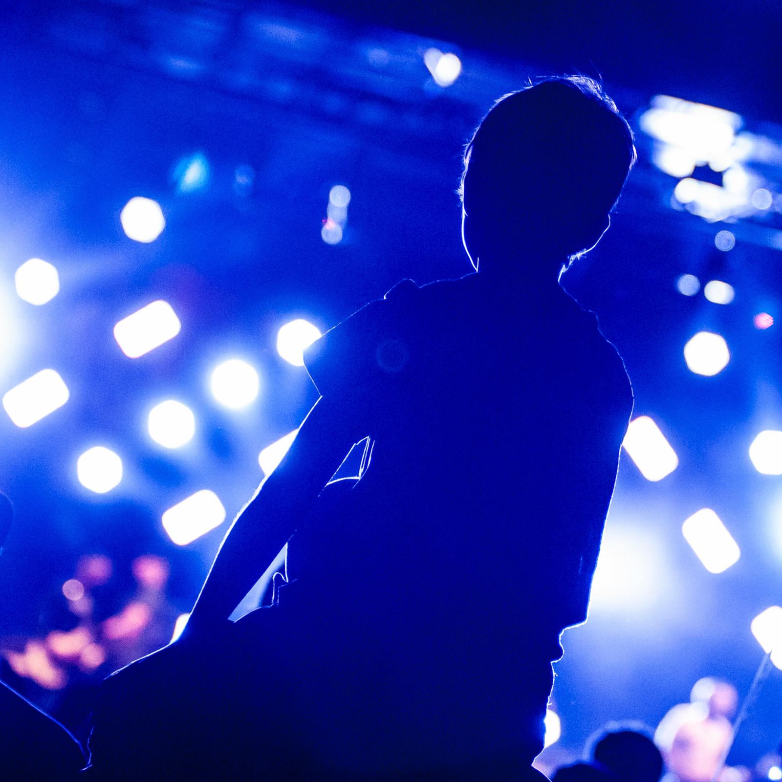 Young person on shoulders at a gig