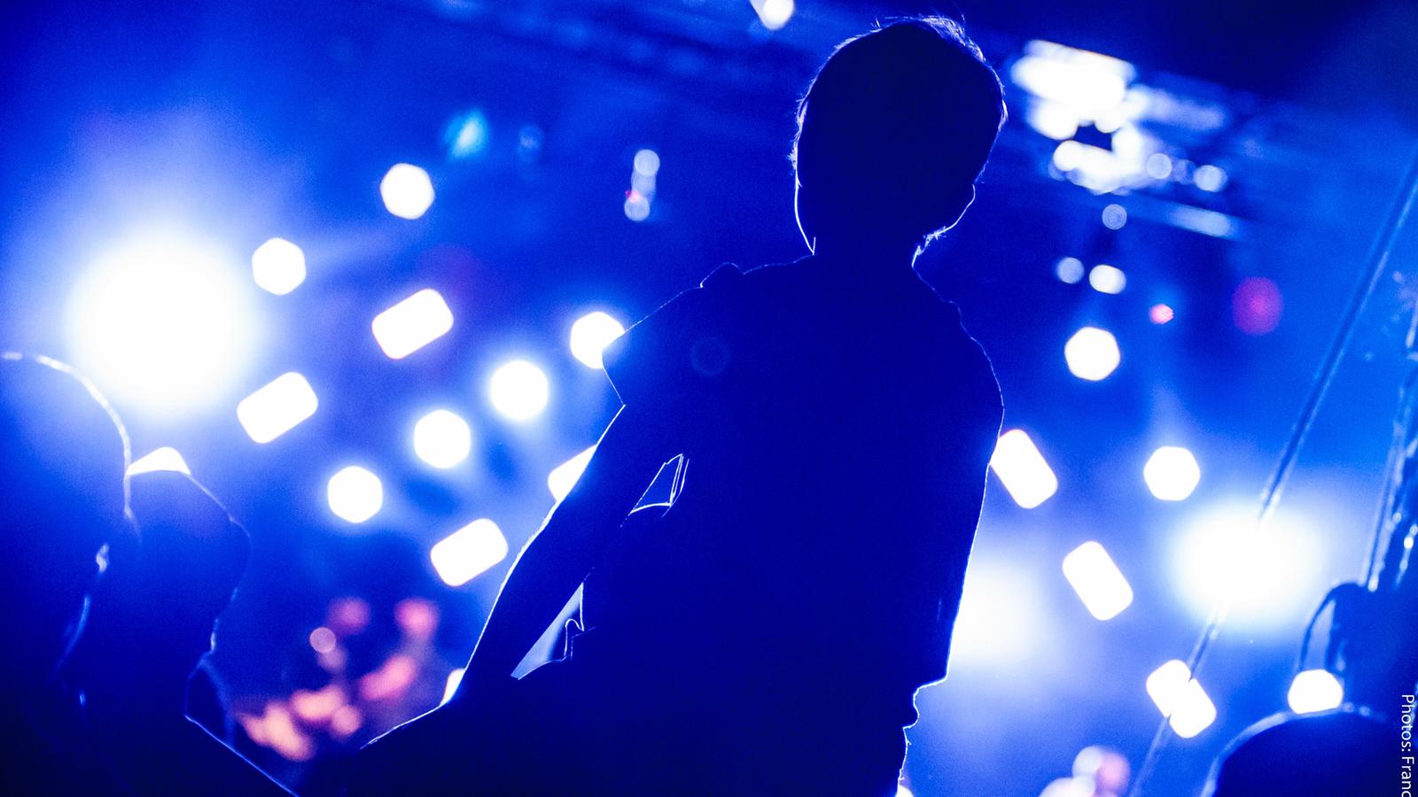 Young person on shoulders at a gig